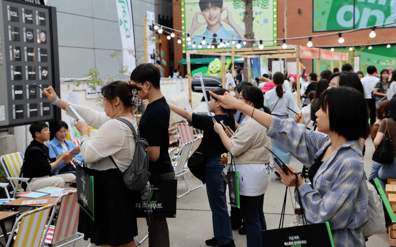 성수 현장에서 참가자들이 스마트폰과 단서를 들고 더 스카우트 미션을 수행하는 모습